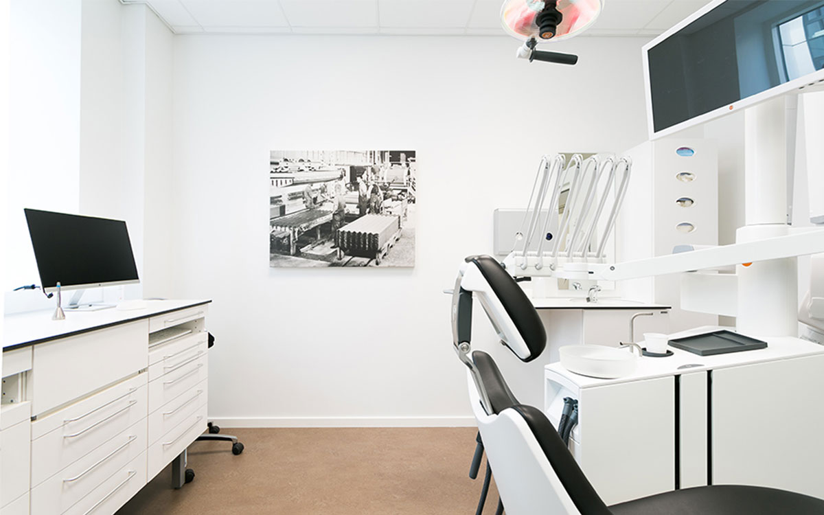 Wnętrze gabinetu stomatologicznego w klinice w Allborgu. Z przodu stoi unit XO z czarną tapicerką.